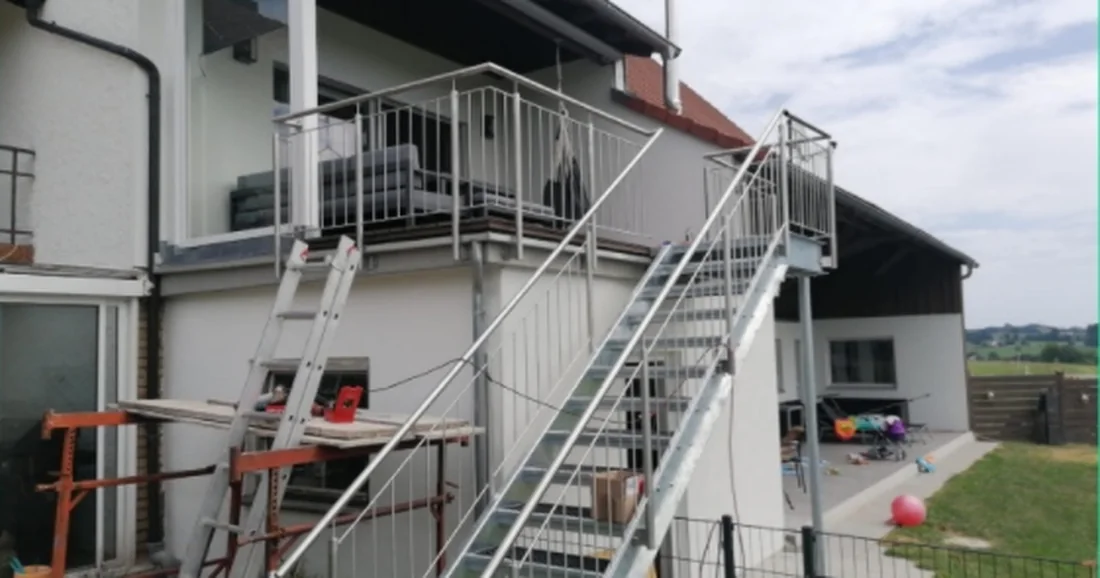 Außentreppe aus Stahl mit Geländer während der Montage an einem Wohnhaus